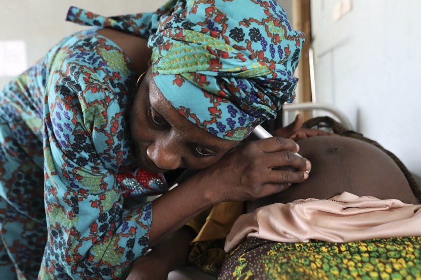 The head nurse at one of the CARE-supported clinics in Maiduguri checks on Fatima Abba Bukar. Photo: Josh Estey/CARE
