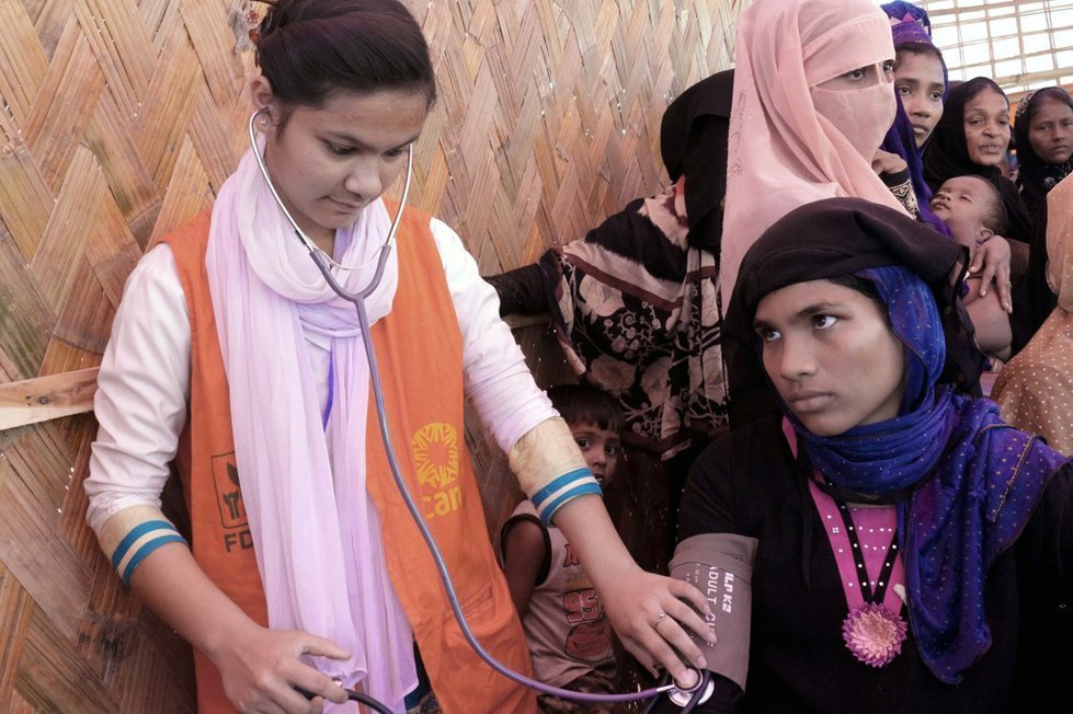Senoara receives medical check up from CARE staff near Balukhali camp in Bangladesh