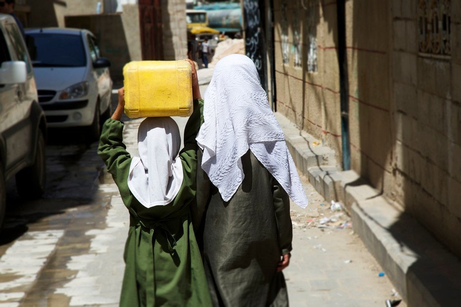 A woman and girl carrying water in Yemen