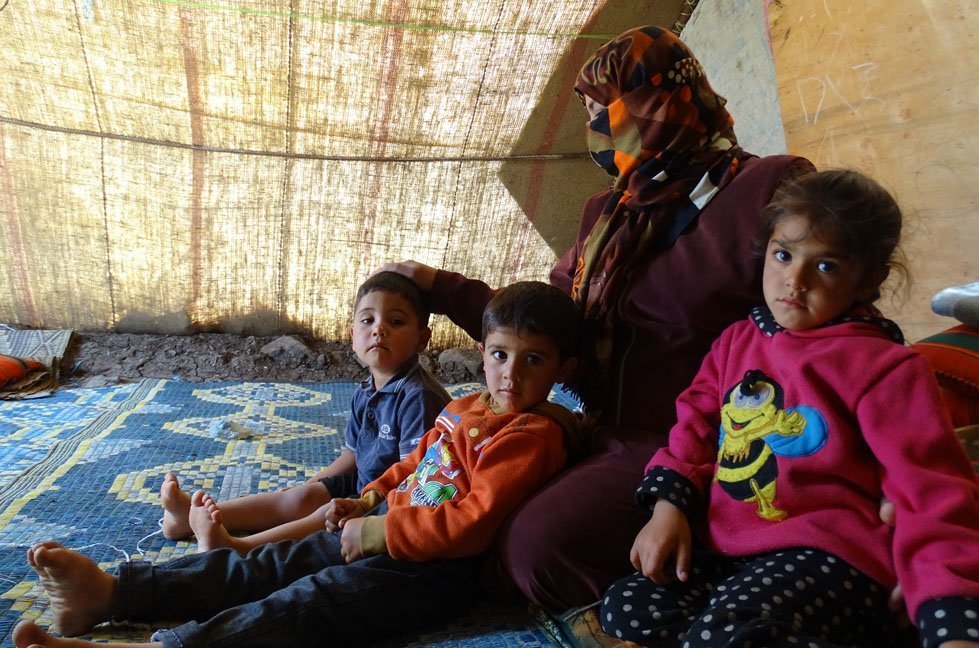 Amani (name changed) with her three children inside Al-Rahma Camp