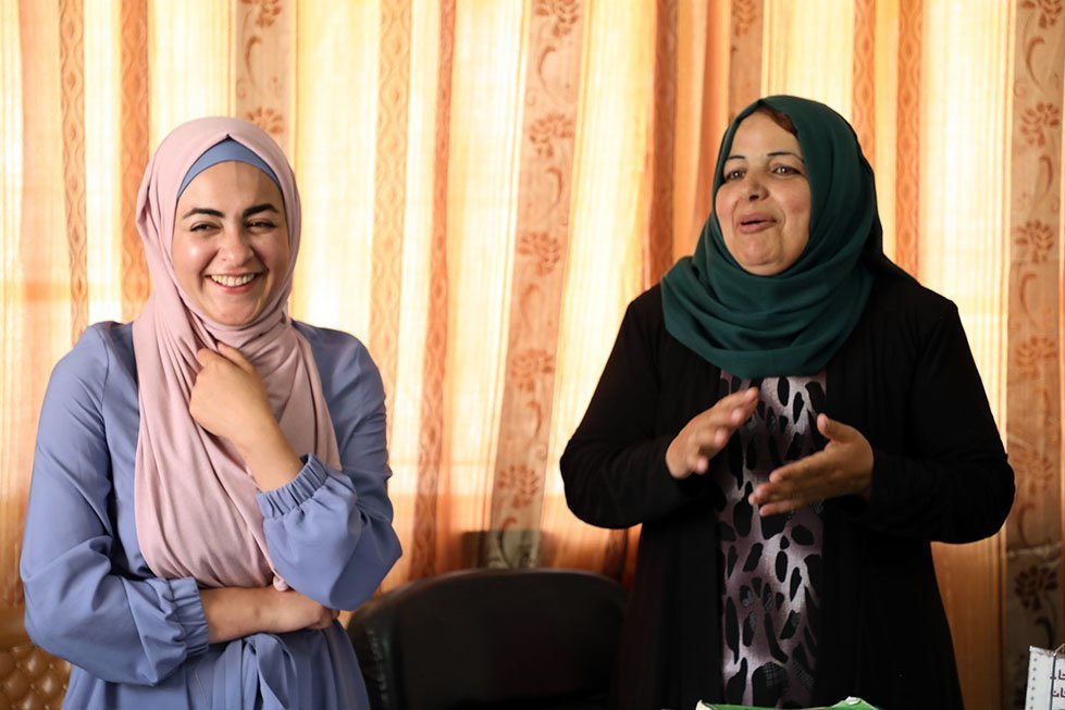 Yusra (right) and Bara'a (left) talk about how Bara'a has helped the co-op market themselves and how inspired Bara'a is by the women's group. Laura Banks/CARE