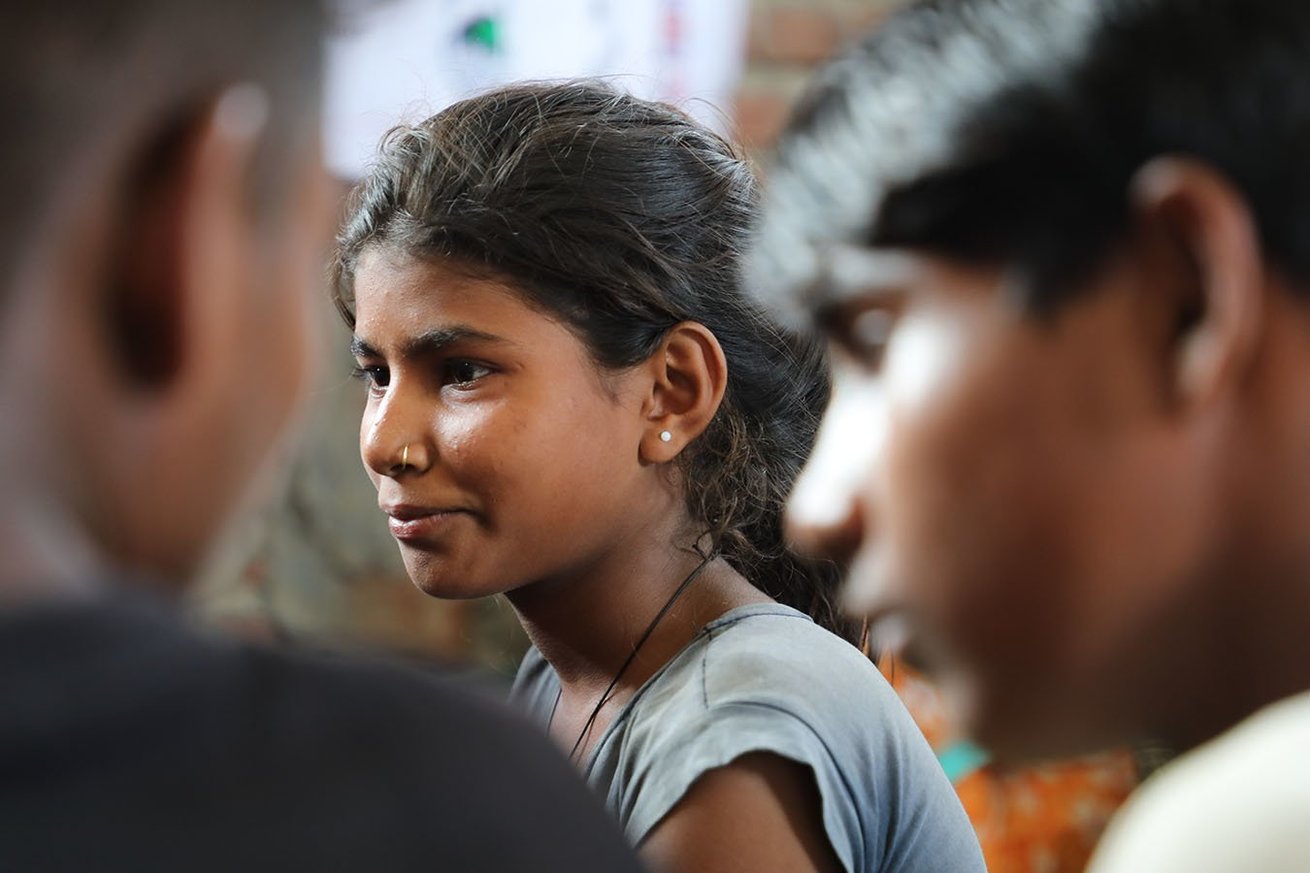 A young girl participates in a discussion with boys in her community about sexual harassment and how boys and girls can work together to prevent it.