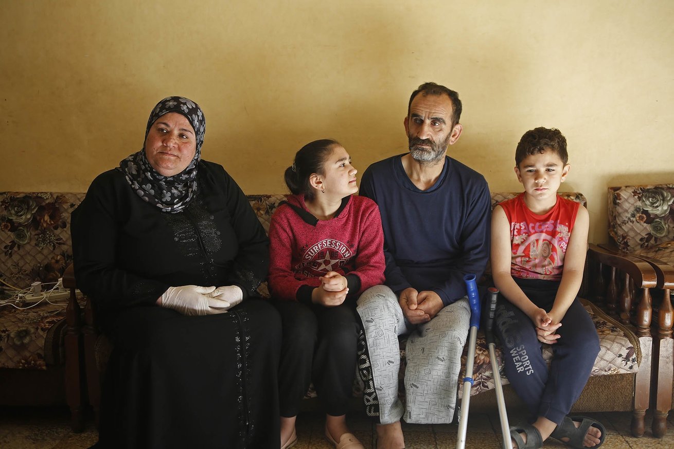 Fatima sits with her family in their small apartment in Tripoli, Lebanon
