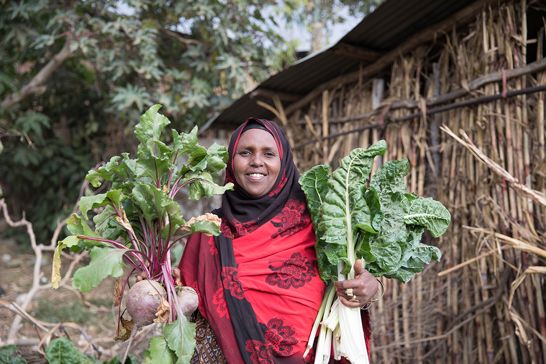 Sergut Abera, mother of three, showcases part of the large harvest from her household garden. She was trained on maternal nutrition and feeding practices as part of GROW.