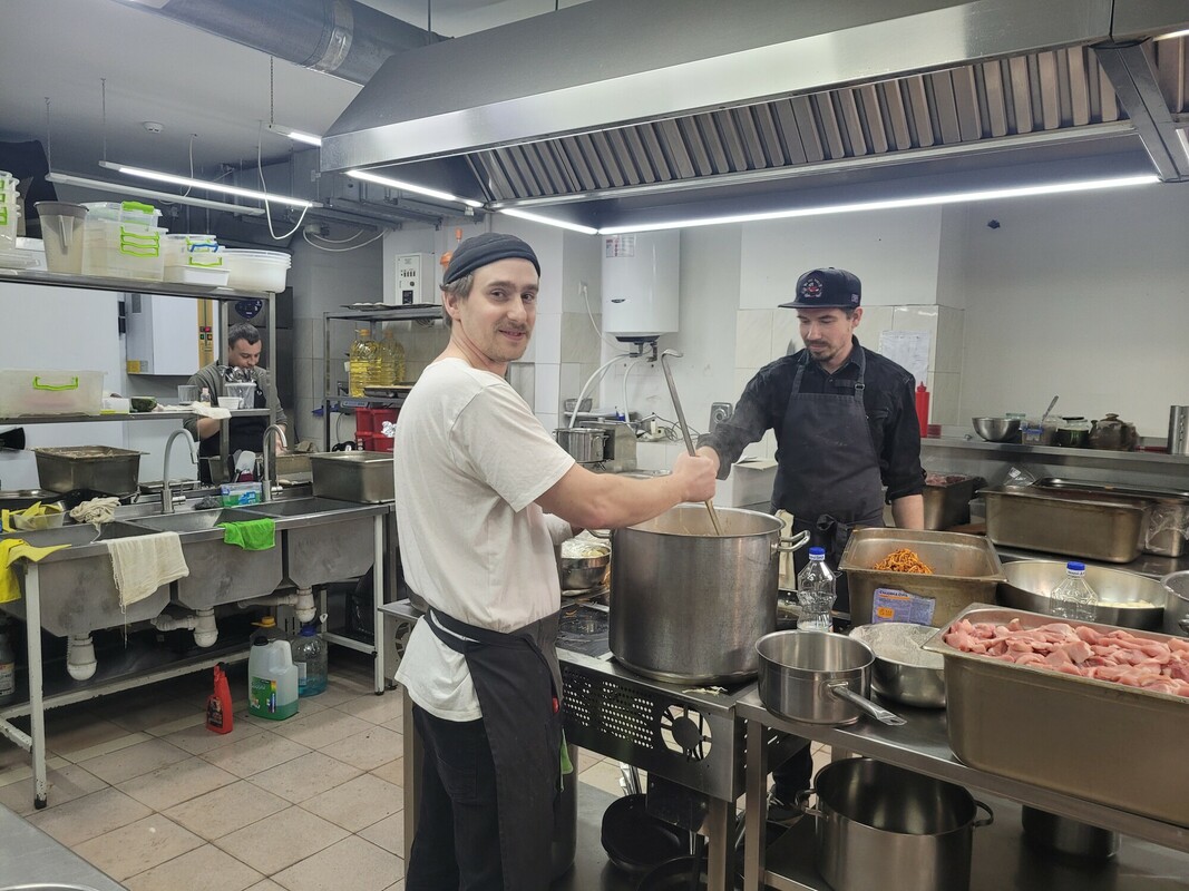 Nikita, 31, working in a kitchen of a restaurant that has been repurposed for the volunteers of 