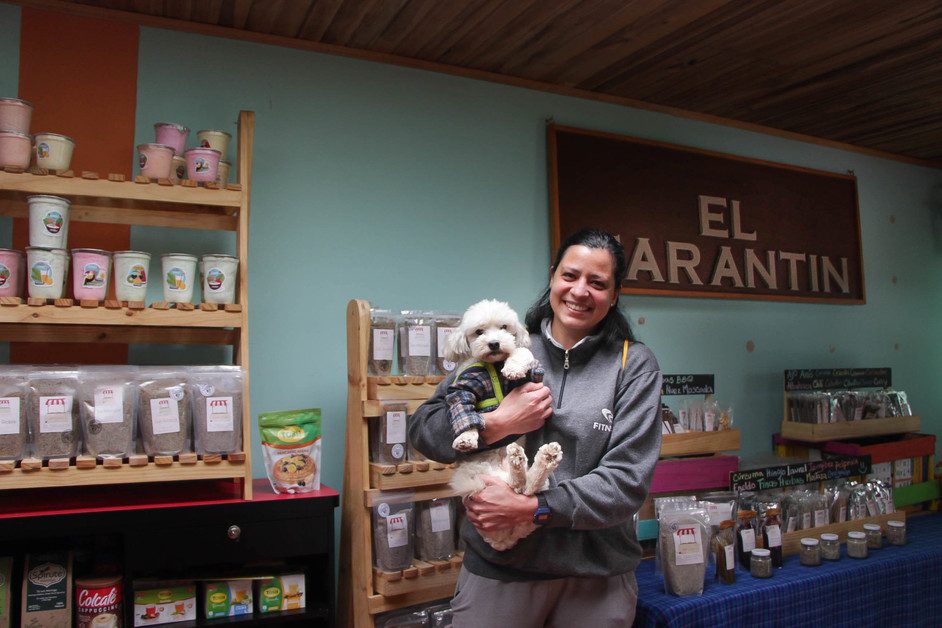 A woman holds a dog in her store