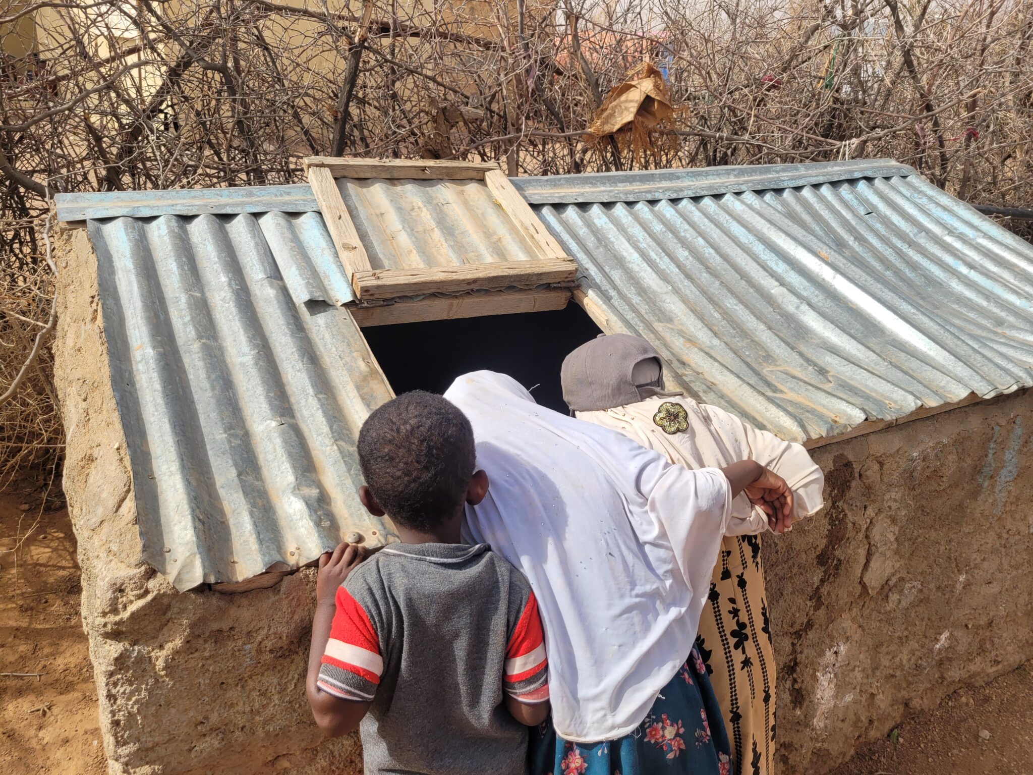 Somalia Asha Mohammeds children look into empty water tank