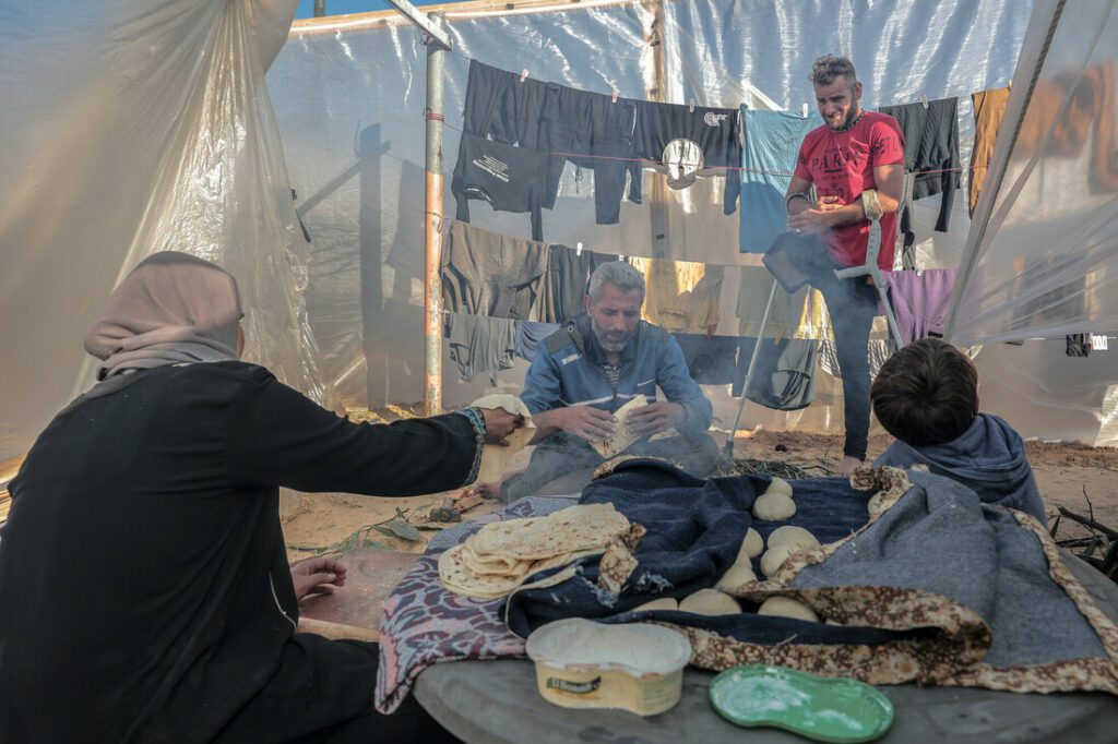 Mahmoud Abu Sadiq (centre) and his family now have to live in a tent made by plastic sheets in a makeshift camp in the town of Tal al-Sultan, Southern Gaza. Photo: Grayscale Media/CARE
