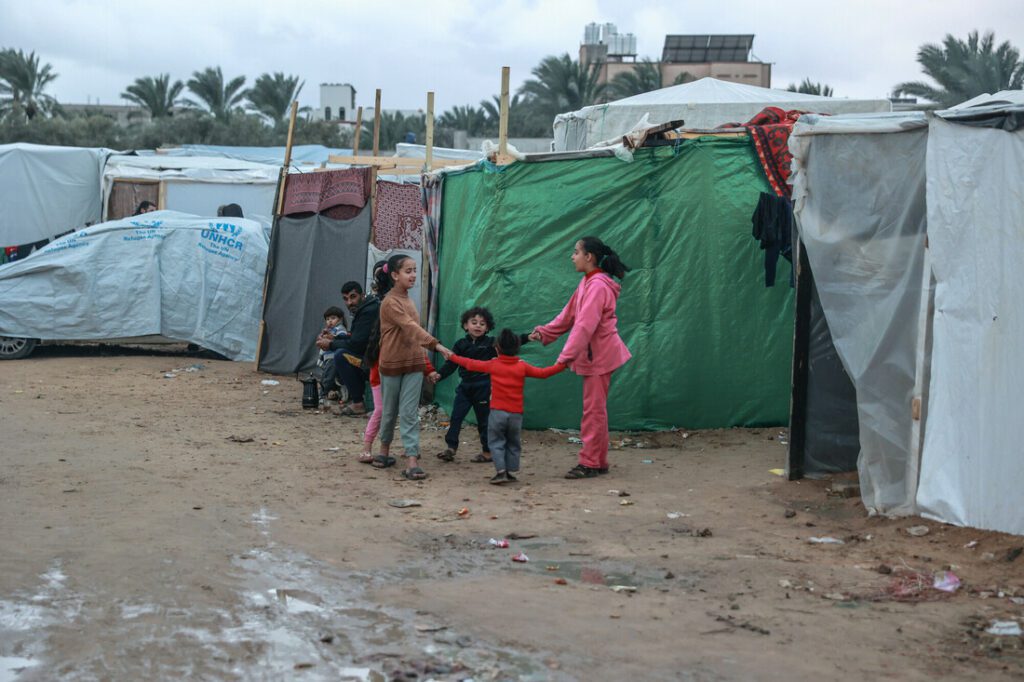 Palestinian children play in front of their family's tent in a makeshift camp for displaced people in Rafah city, near the Egyptian border in Southern Gaza. Photo: Grayscale Media/CARE