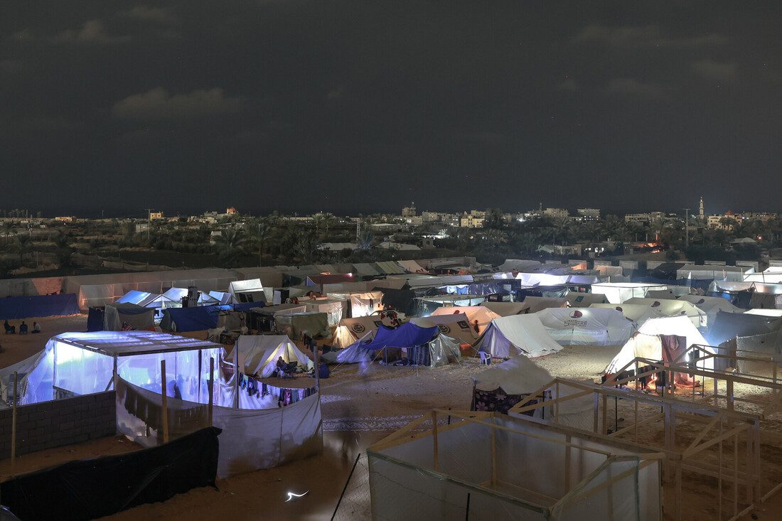 A landscape of tents in the dark. undreds of displaced Palestinians have erected makeshift shelters out of wooden two-by-fours and nylon tarps in Rafah city, near the border with Egypt.