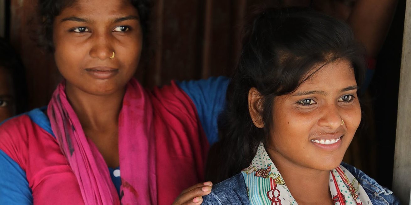 Two members of a CARE girls' collective gather before their meeting. Sadhana, in the foreground, stopped her own child marriage and then helped others in her school and community understand why and how child marriage can be prevented.