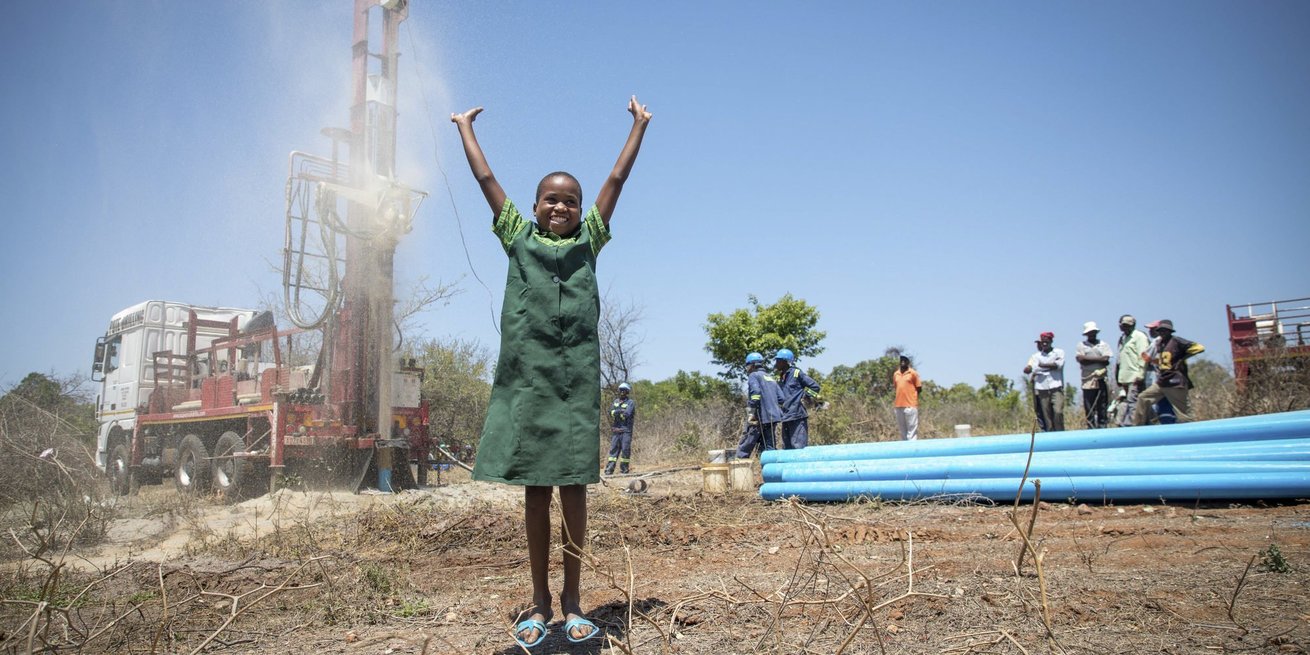 Precious is overjoyed my seeing water come out of a new borehole CARE gave her village in Zimbabwe 